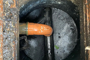 drainage system showing dark water and pipes with three visible components